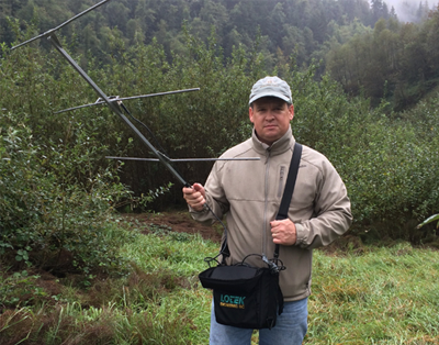 Student with radio transmitting equipment in the field 